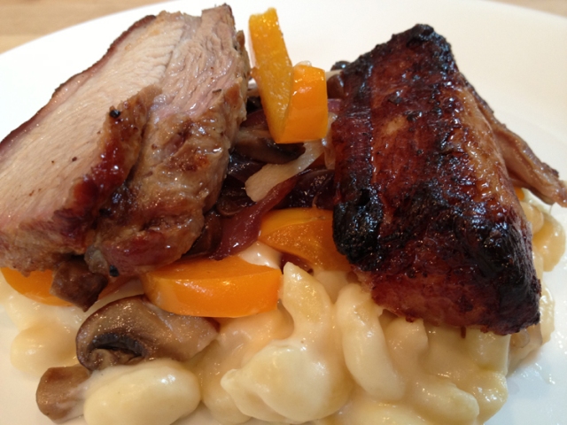 Pork belly, adorning a pile of macaroni & cheese with sauteed vegetables